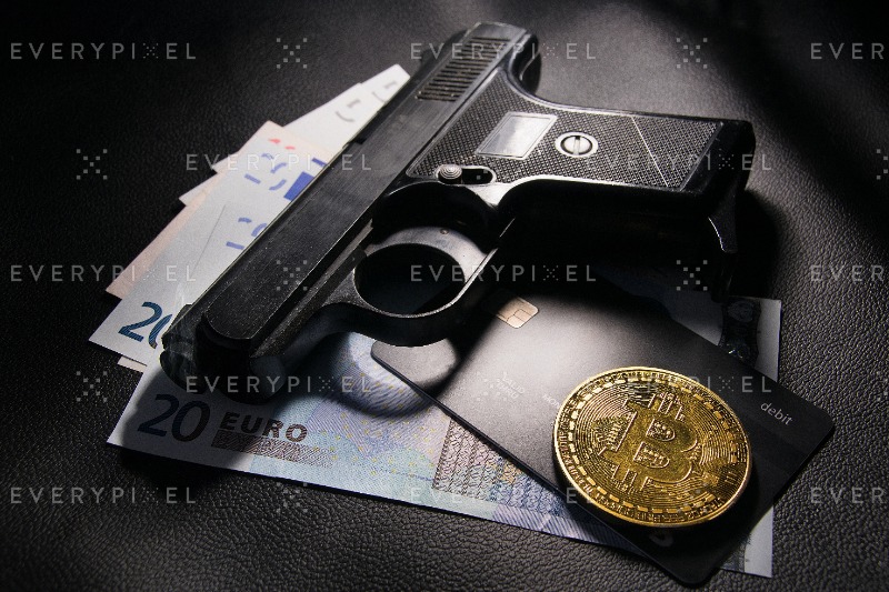 criminal Euro money and gun in the light.
